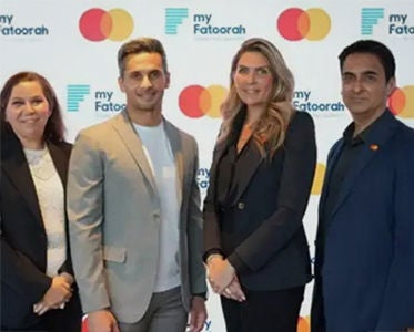 Four individuals stand in front of a backdrop featuring the logos of 'my Fatoorah' and 'Mastercard', highlighting their collaboration.