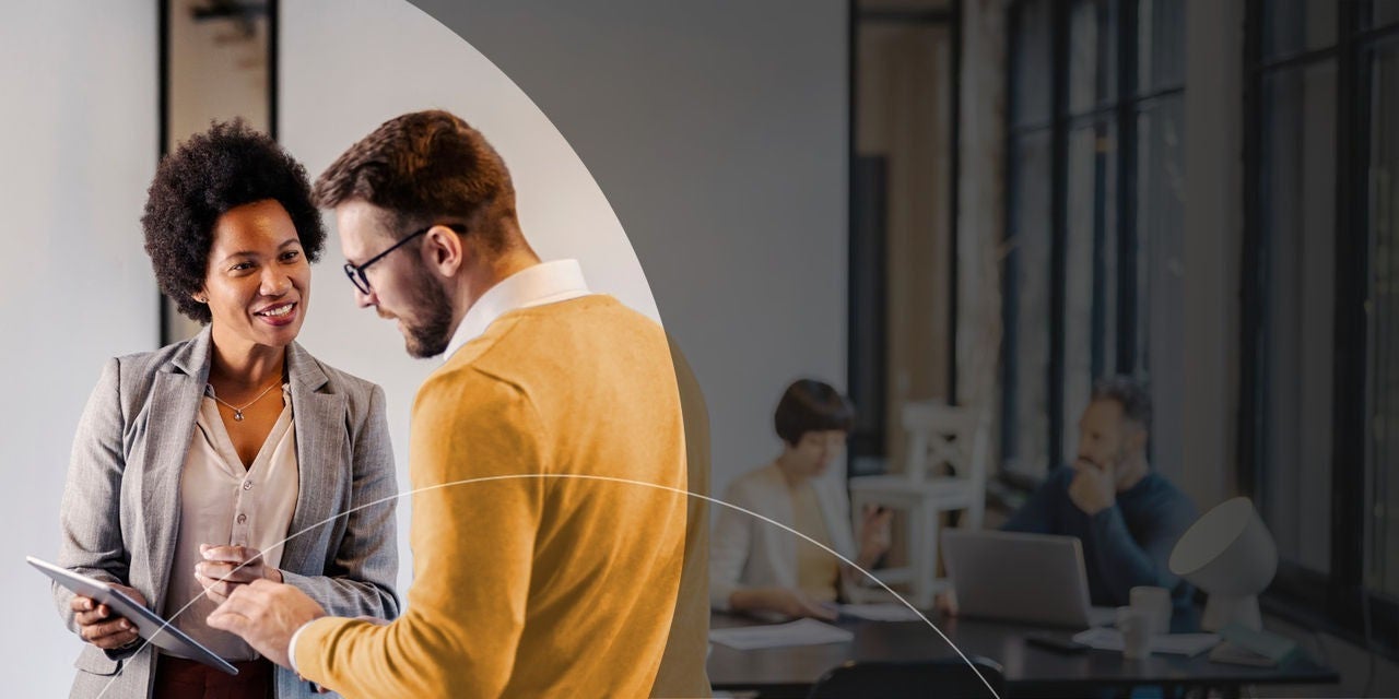 שני אנשים מנהלים שיחה בסביבה משרדית, ומחזיקים טאבלט.