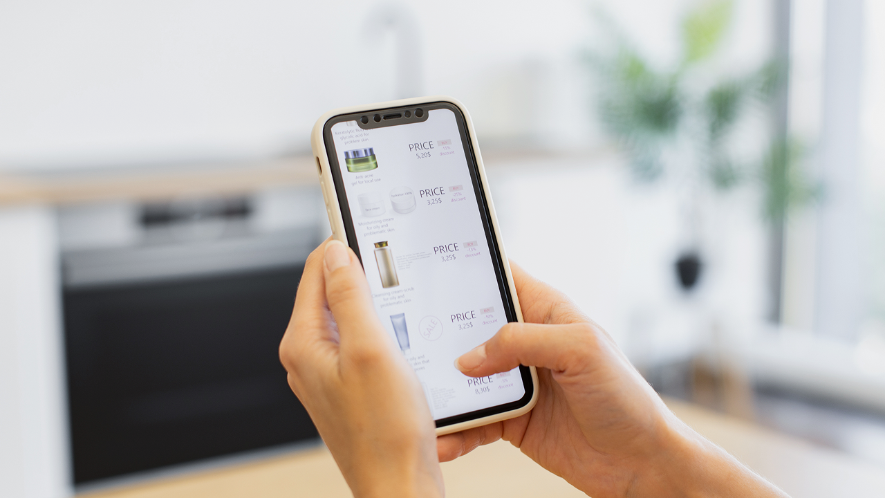 A person using a phone to shop with prices listed on it
