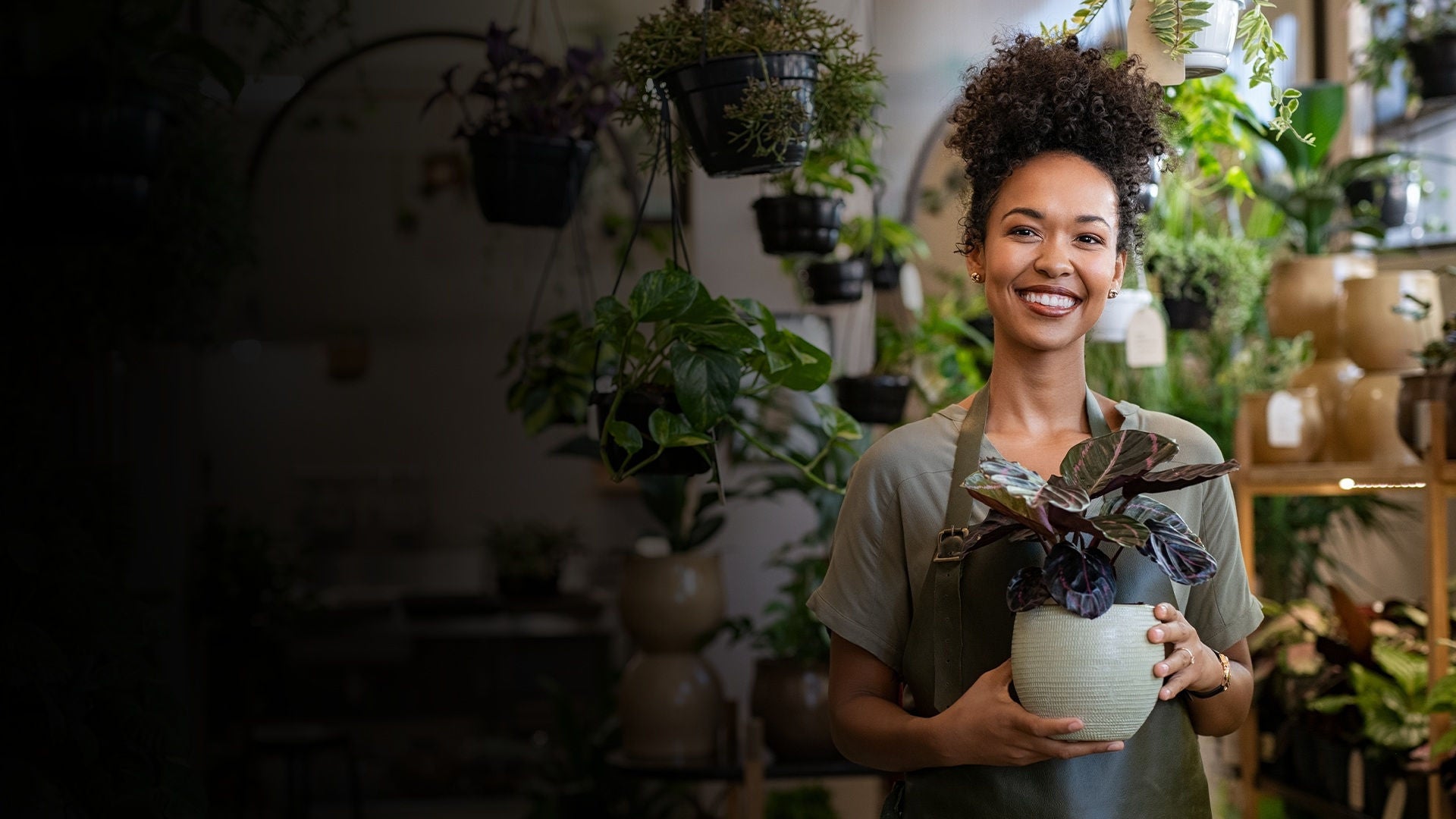 Woman in retail setting holding plant