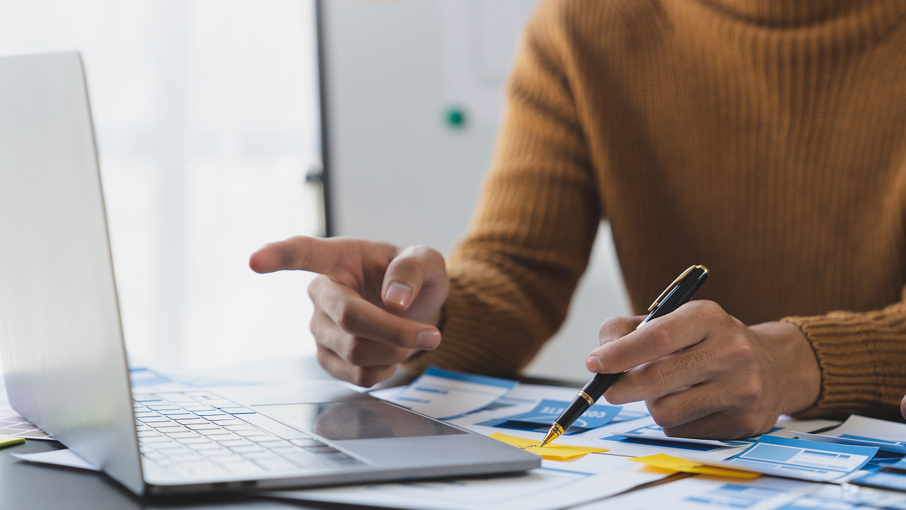 A person with a pen using his laptop
