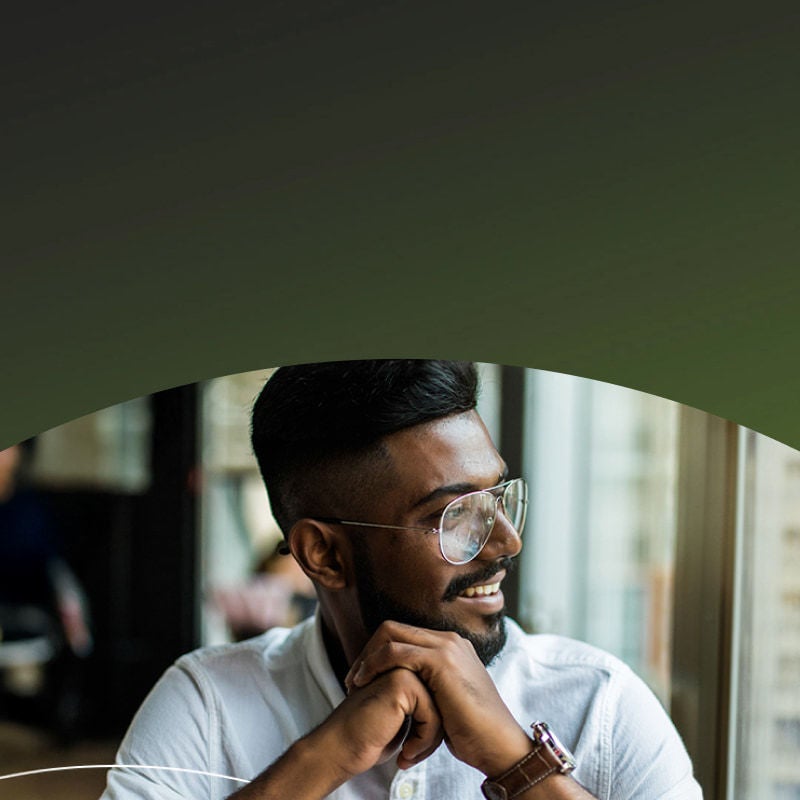 smiling man with glasses looking out the window