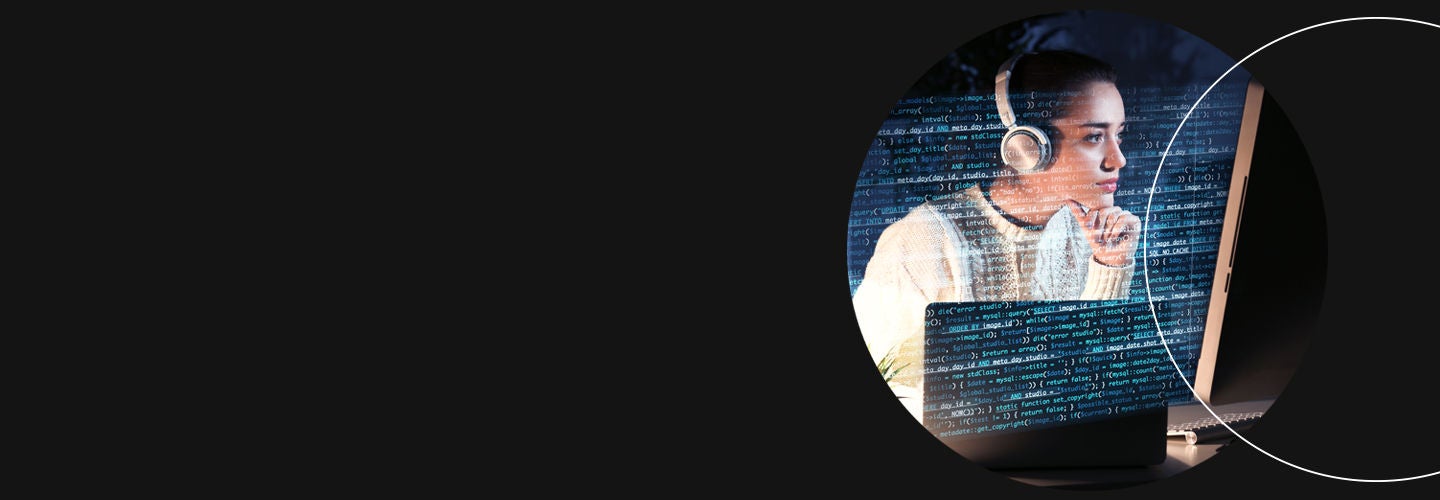 Woman looking at a computer with headphones on