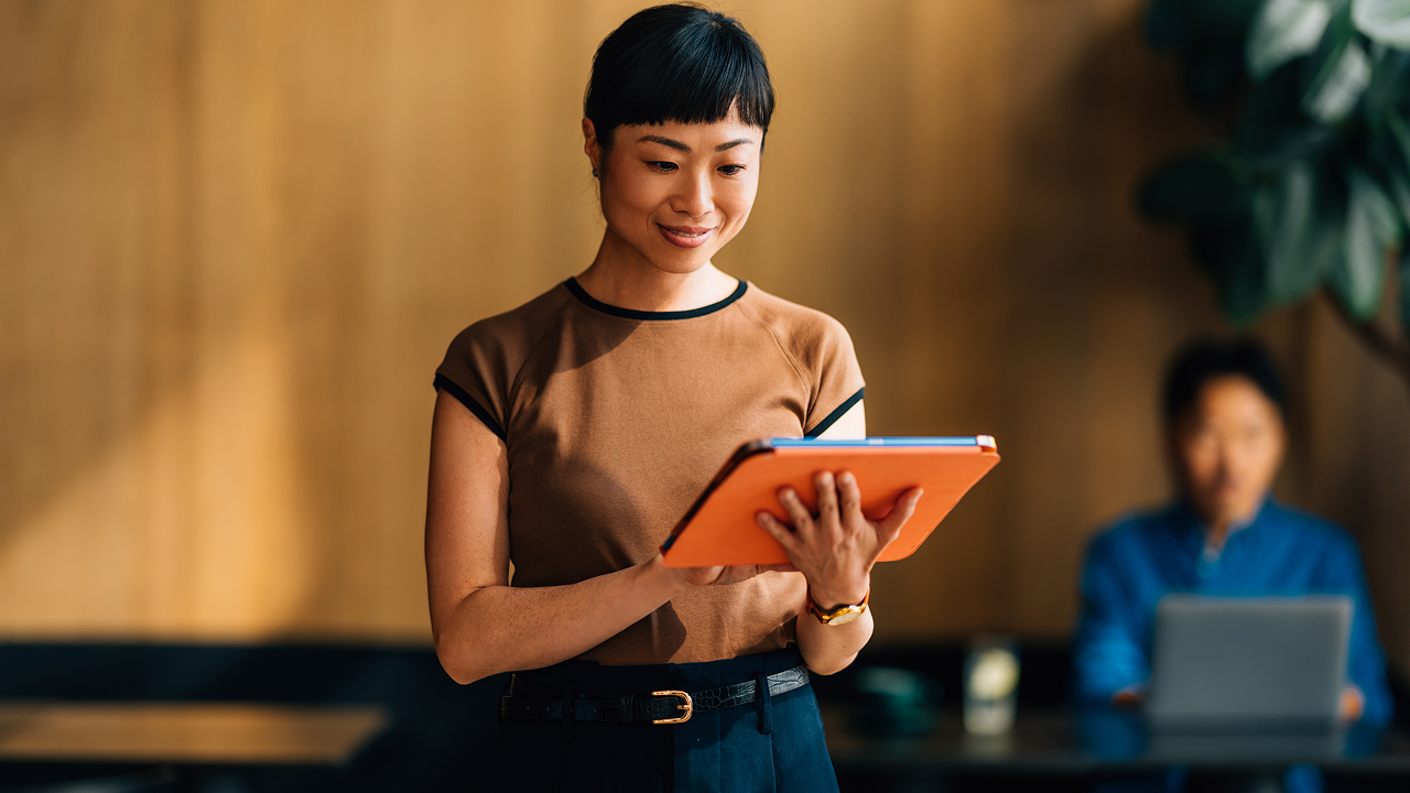 A woman holding a tablet and smiling