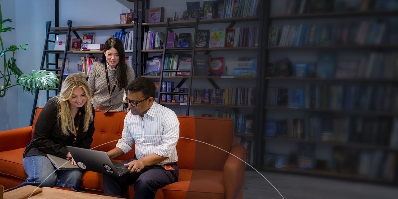 شخصان يجلسان على أريكة ويستخدمان جهازًا لوحيًا معًا.