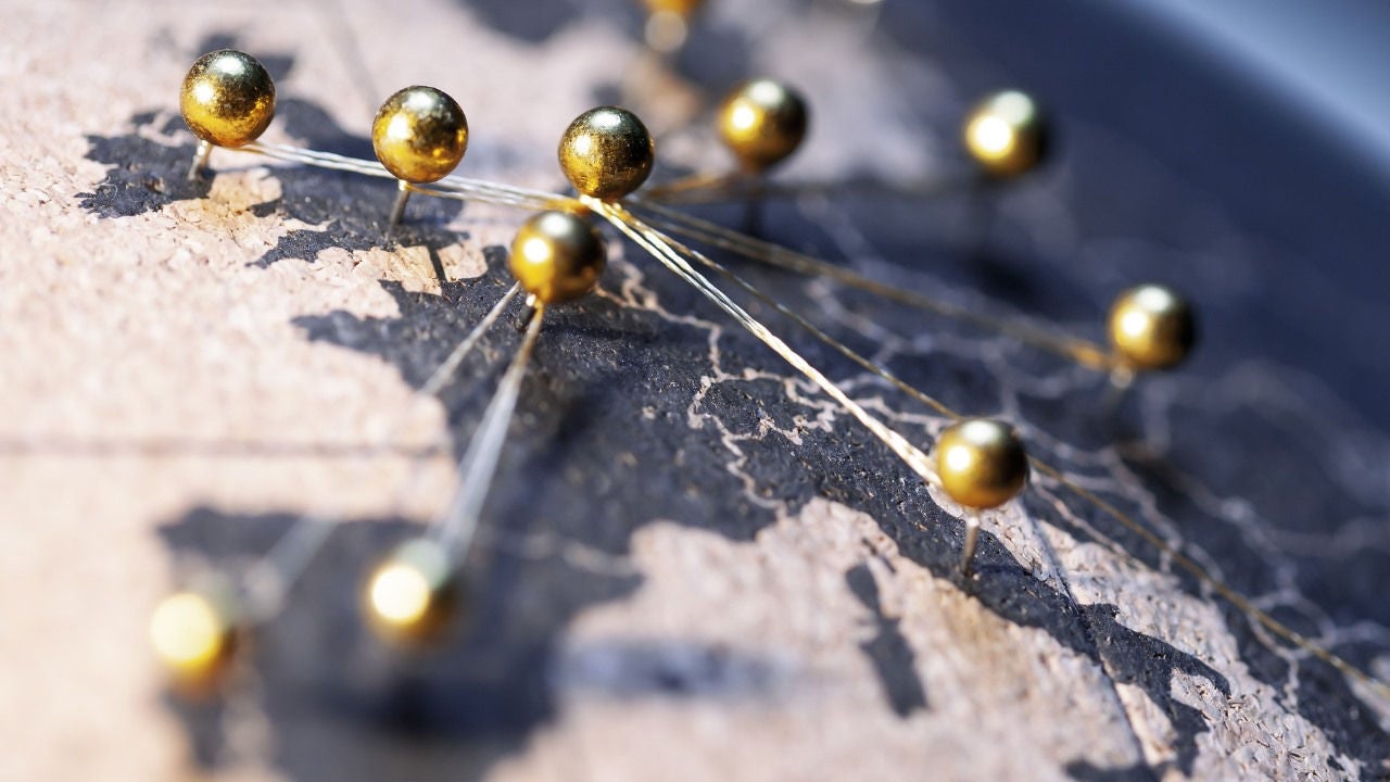 A map of Europe with brass pins on the capitals. 