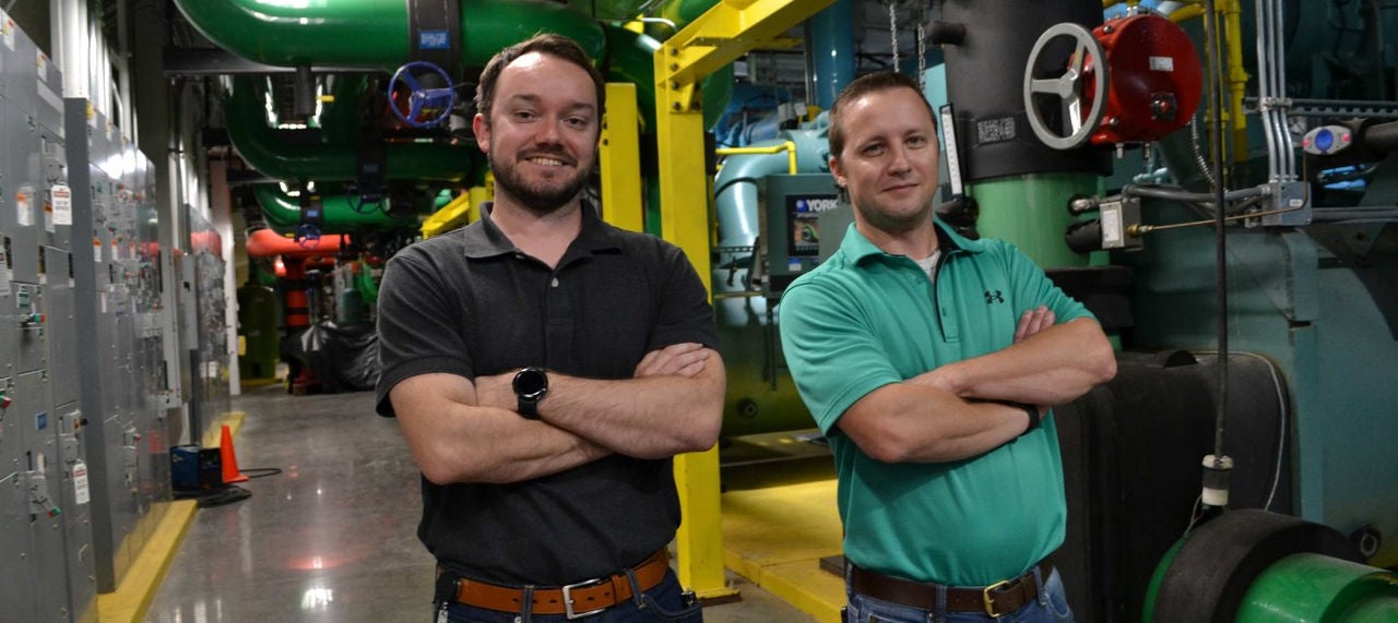 Two men stand with their arms crossed and smiling in Mastercard's chiller room in the St. Louis Tech Hub. 