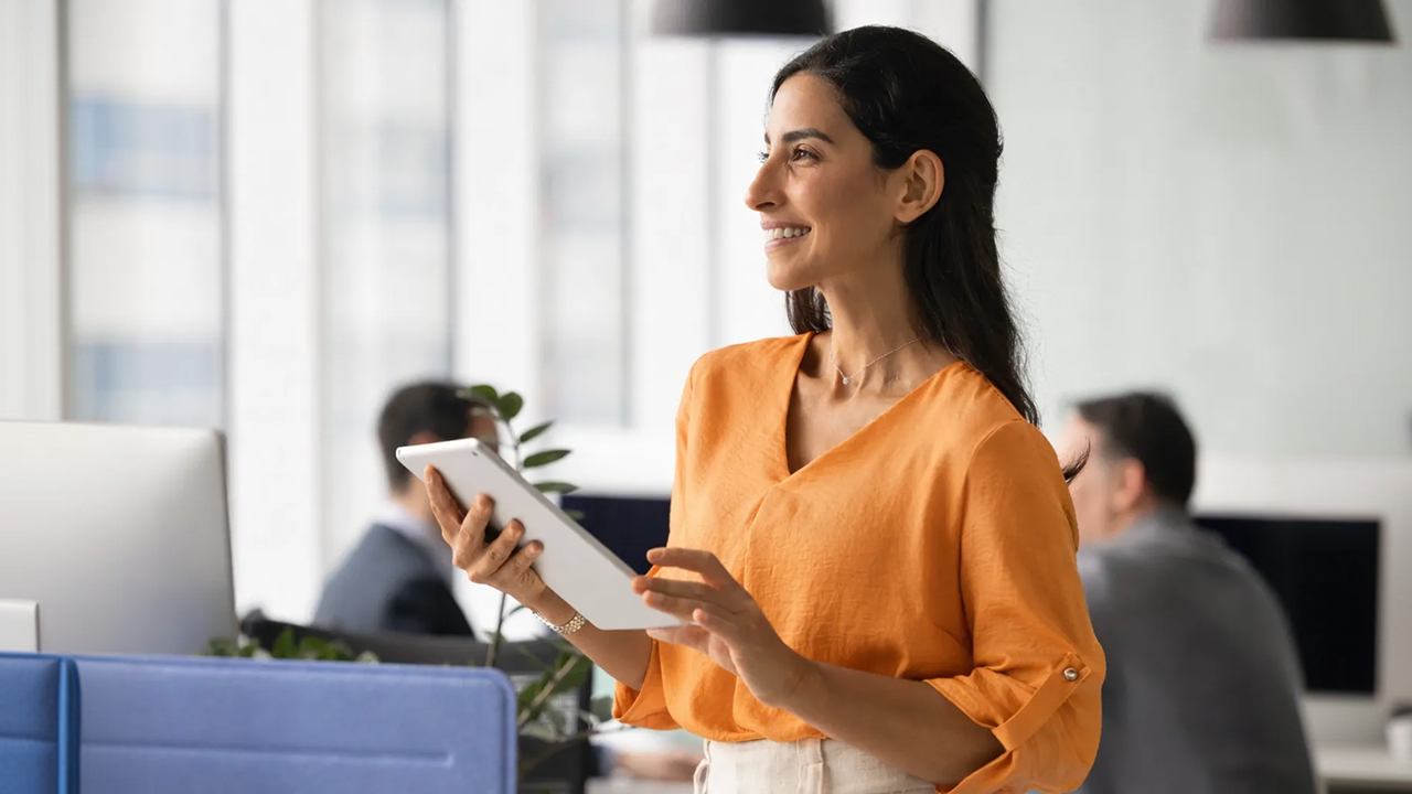 A woman in an office looking at her tablet