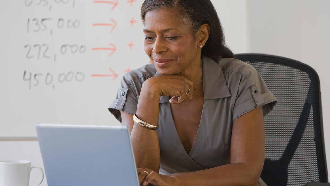 A mature businesswoman looking at a laptop.