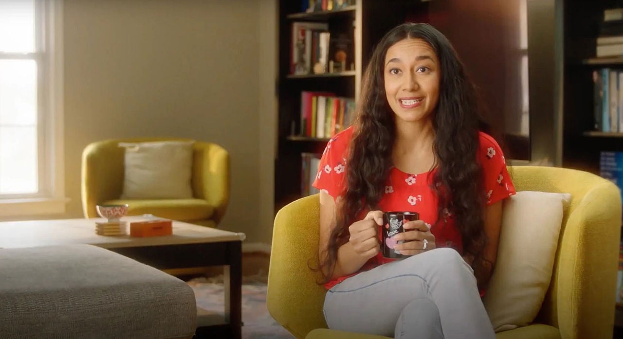 Woman smiling, holding a mug