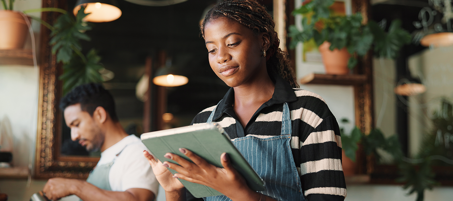 Barista looking over the stock on a tablet
