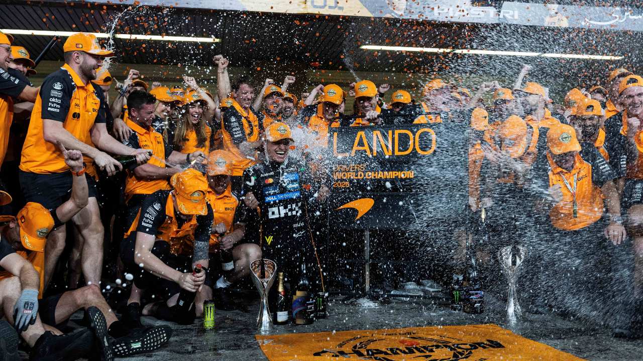 The McLaren Racing team celebrating Lando Norris's driver championship win by spraying Champagne in 2025. 