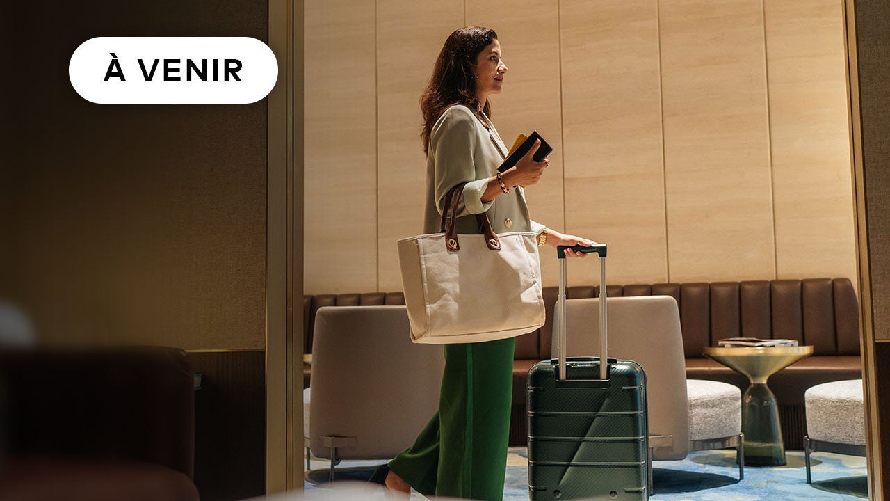 Woman with luggage in hotel.