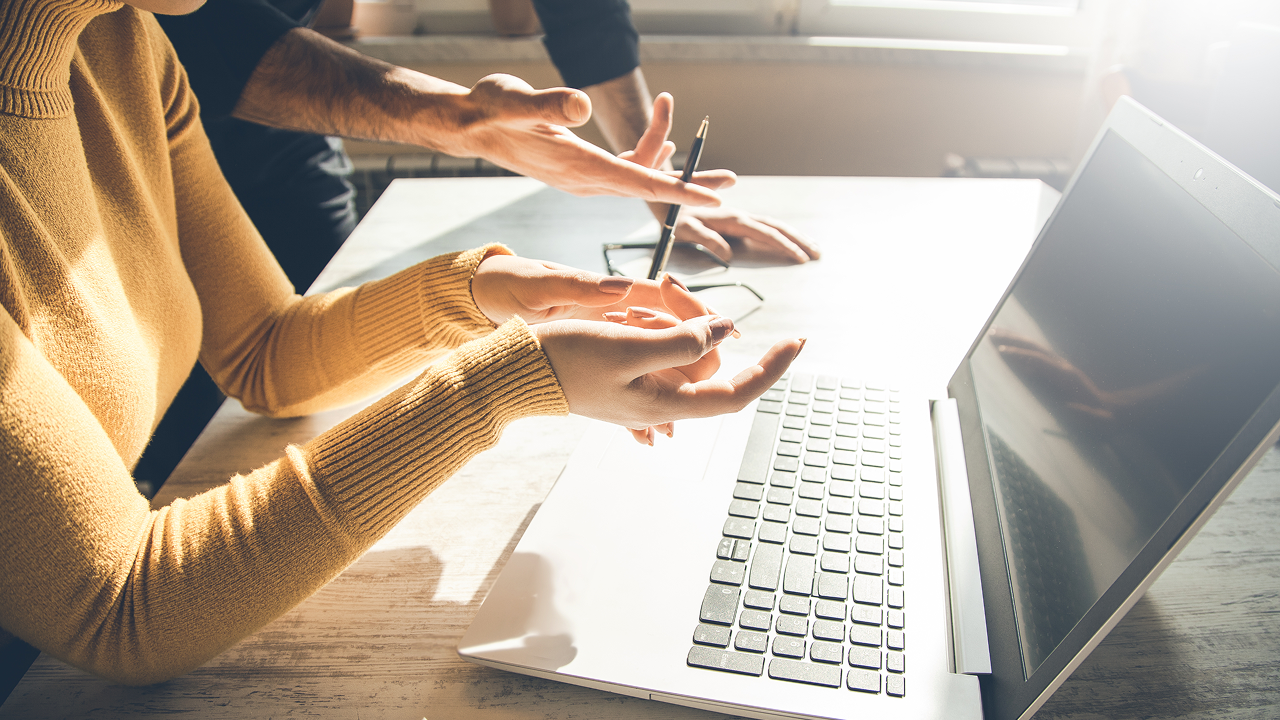 Hands above laptop
