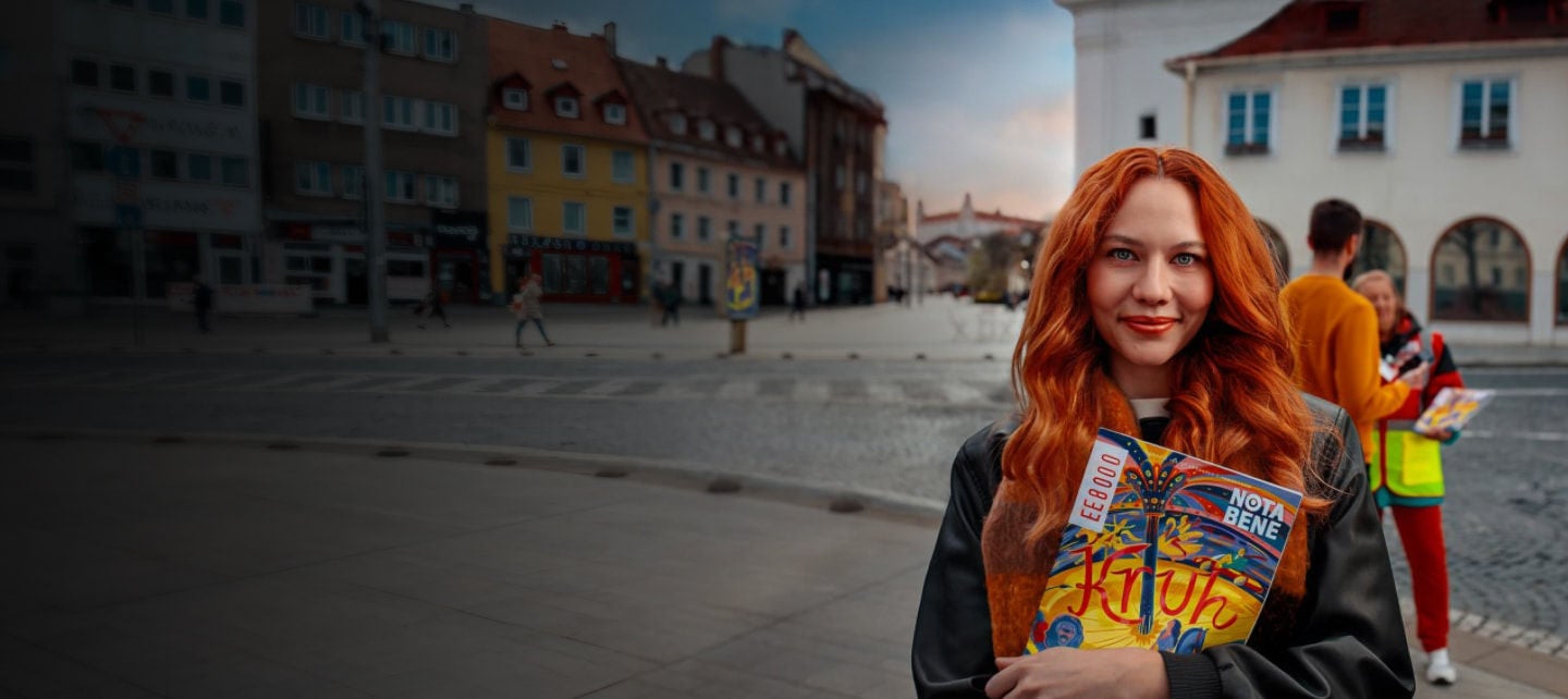 ryšavá žena drží časopis a usmieva sa