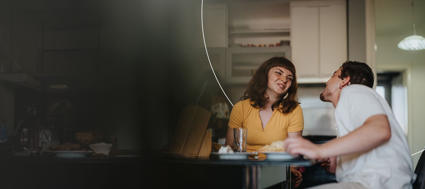 Man and woman sitting at a table looking at each other.