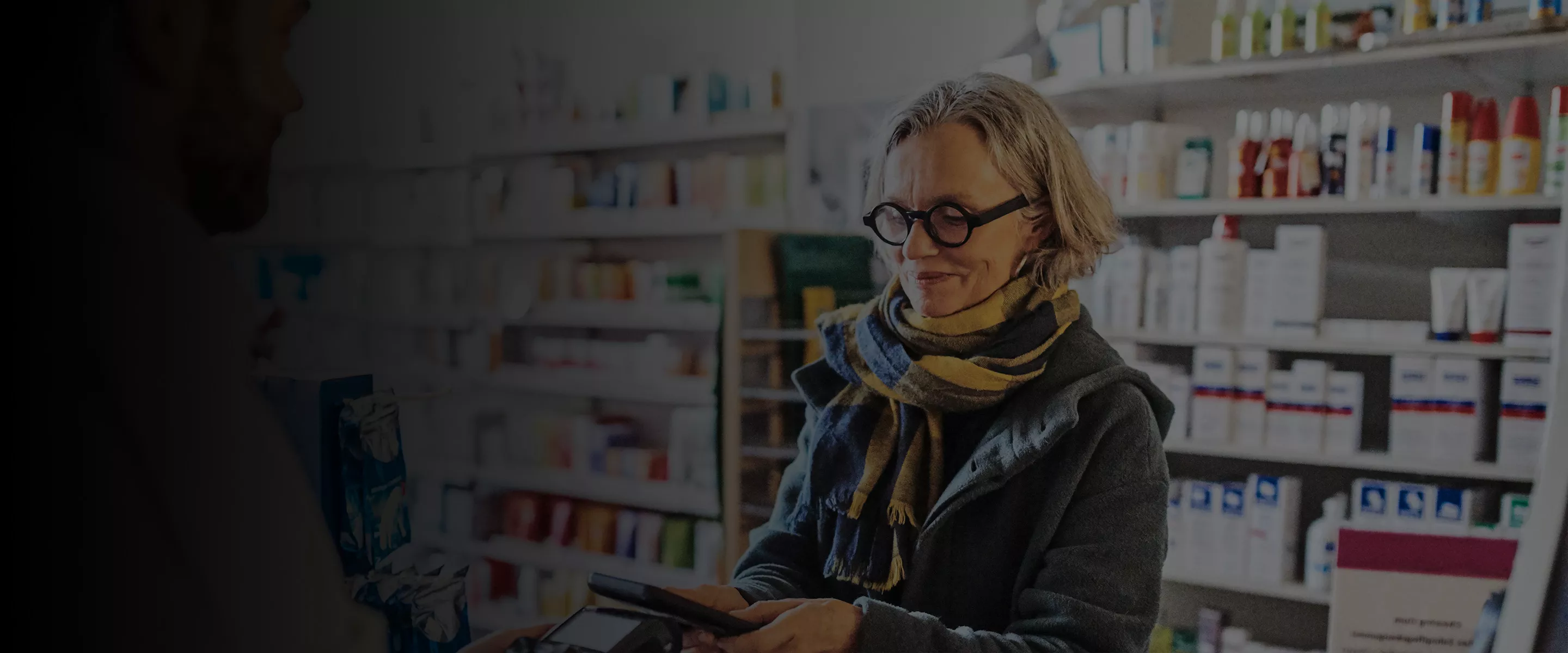 Woman looking at her phone in a pharmacy