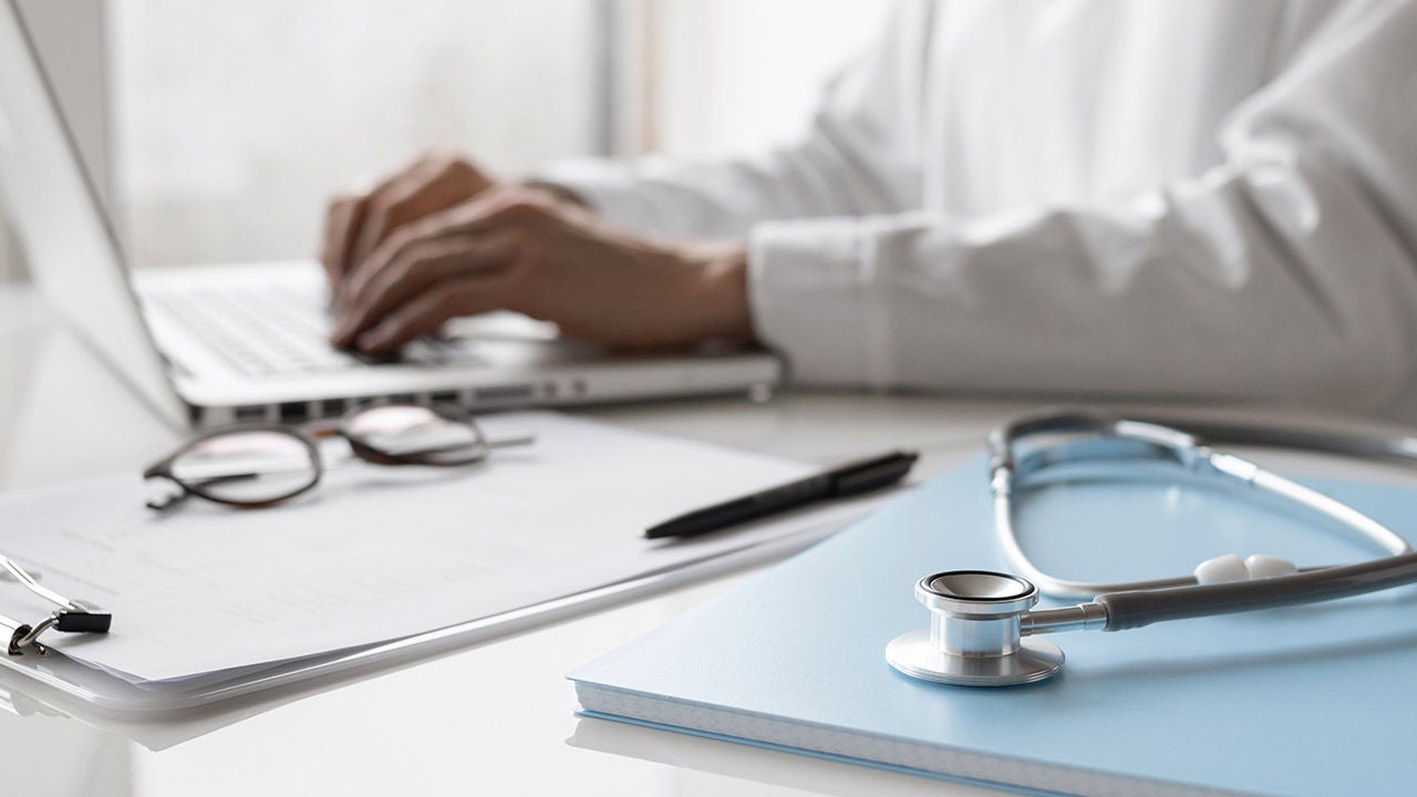 Medical professional working on a laptop.