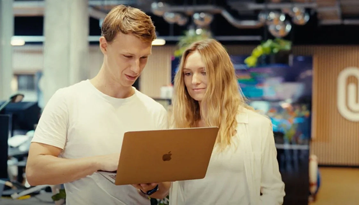 Junger Mann und Frau mit Laptop bei der Arbeit