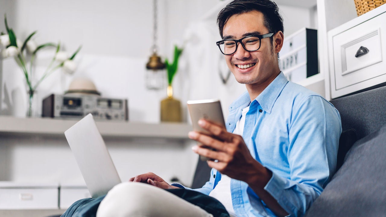 Man working on sofa using phone
