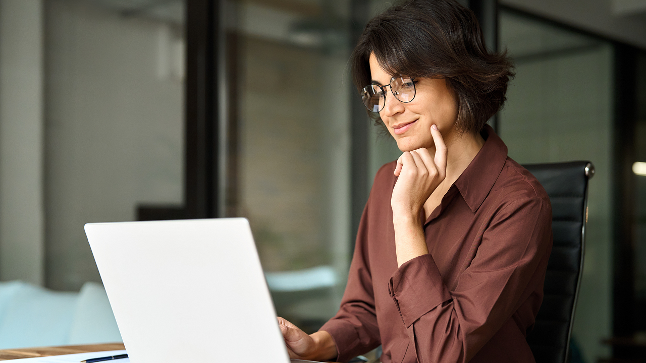 A woman sitting at a desk with a laptop