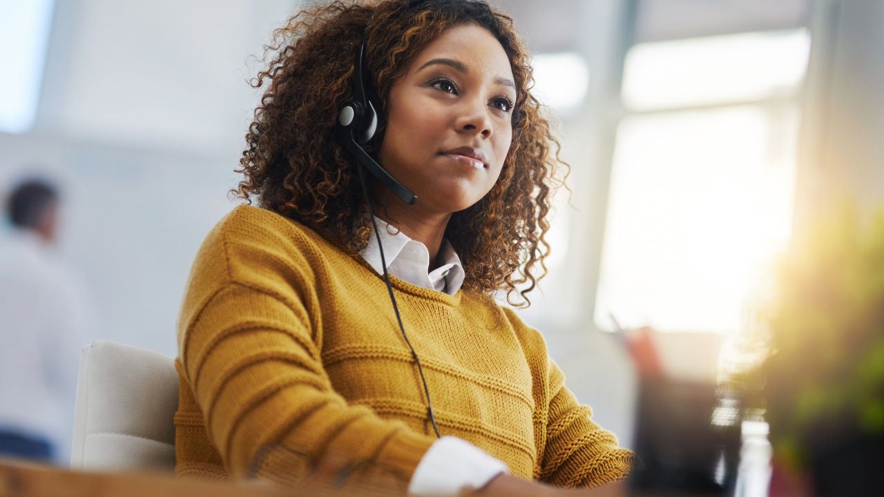 A man sits in a chair and looks at his laptop. 