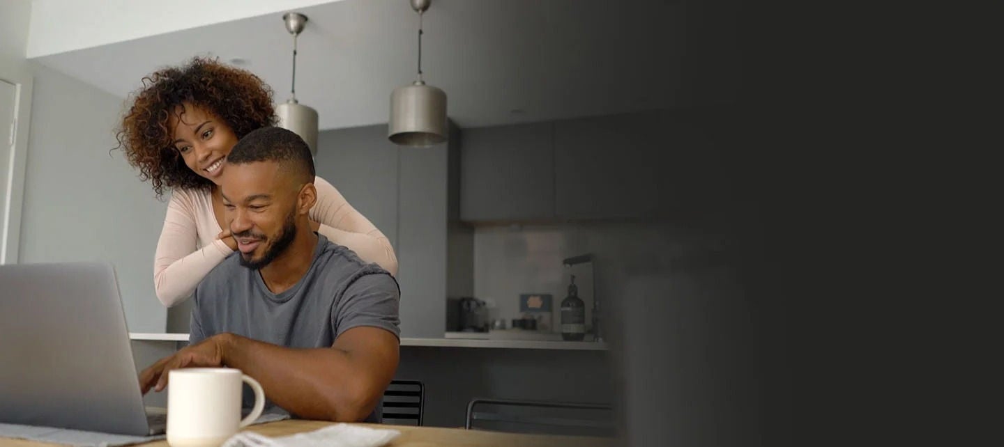 אישה וגבר מסתכלים על מחשב נייד ובוחנים אפשרויות והטבות של כרטיס World.