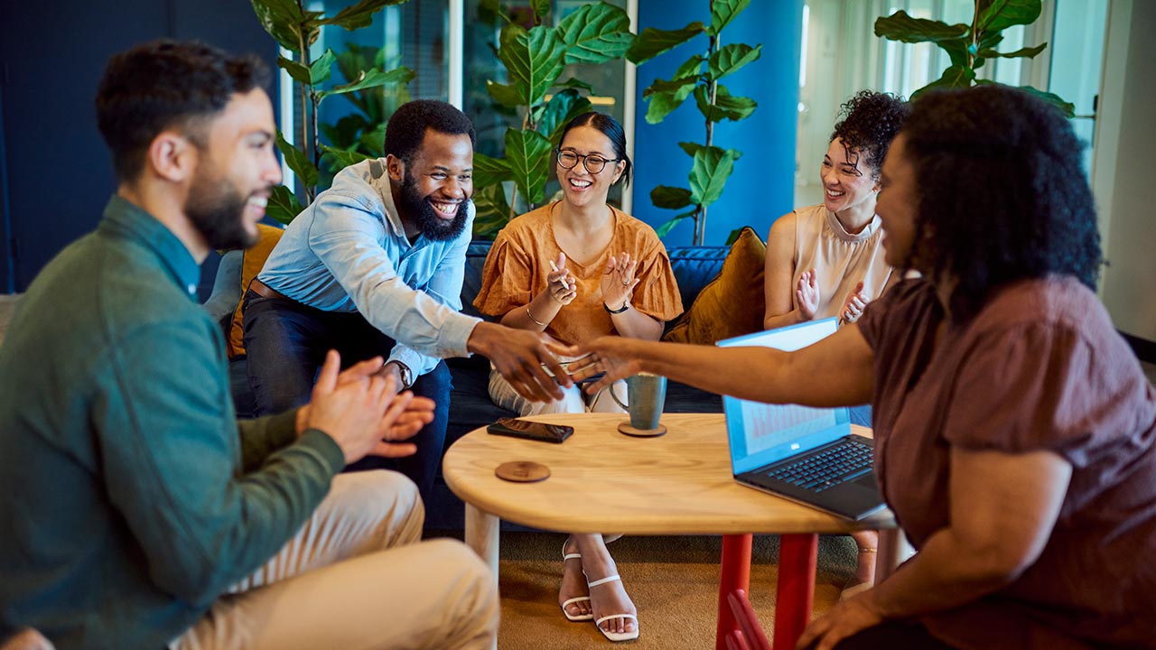 Cheerful, bearded businessman shaking hands with a group.