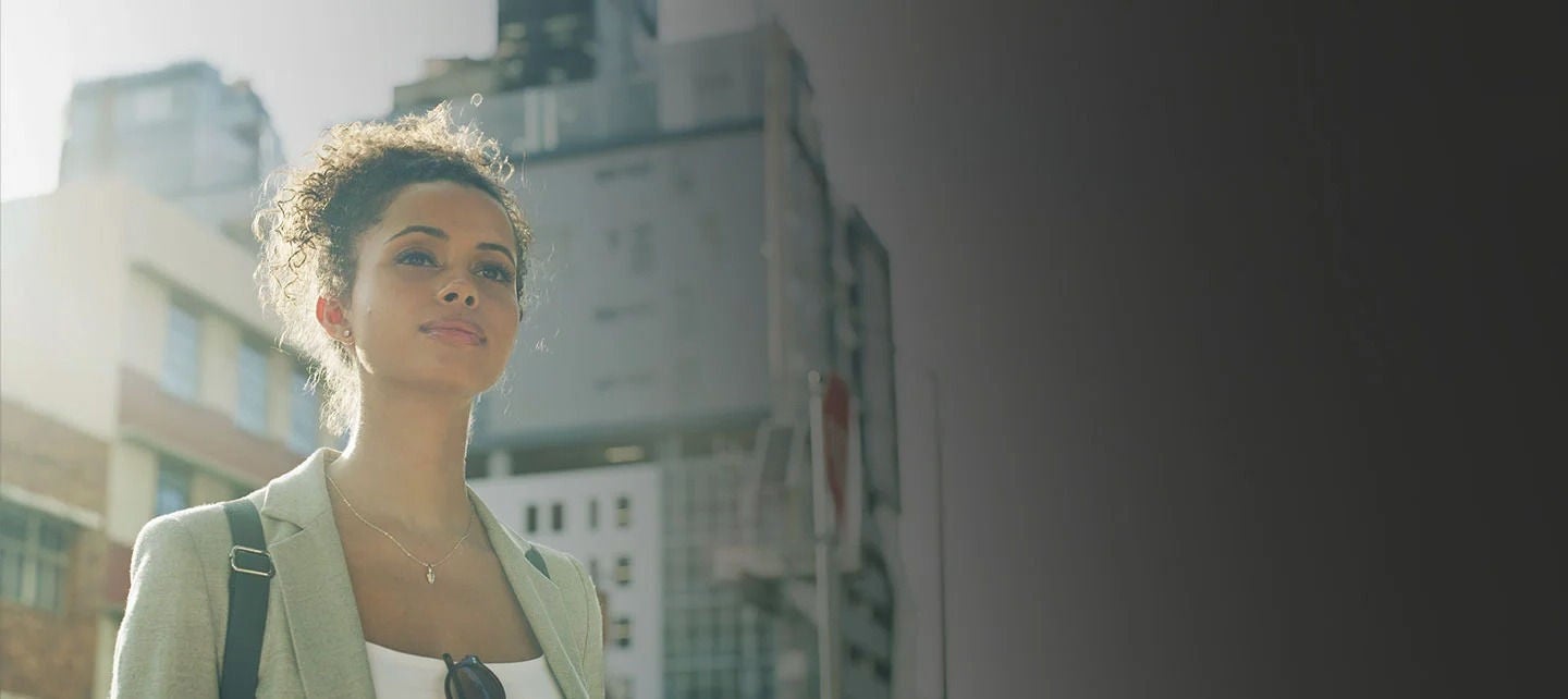 אישה עומדת מול בניינים.