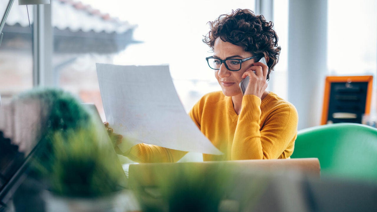 Woman busy on phone in office.