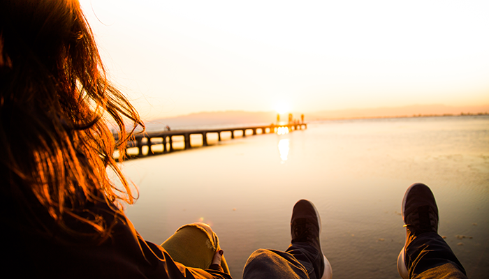 Couple looking at the sunset over a bridge