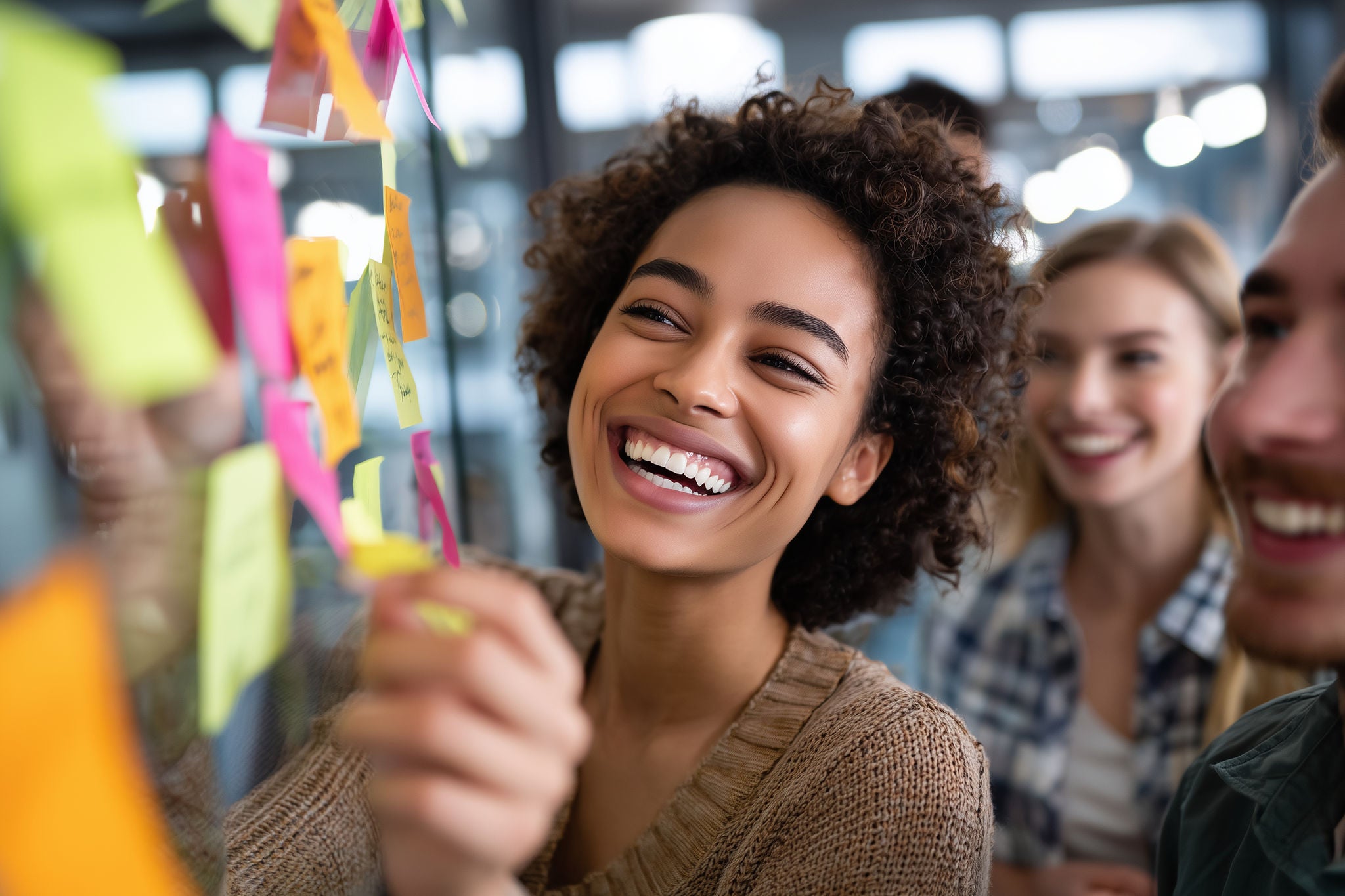 Men and women placing post it notes on a wall
