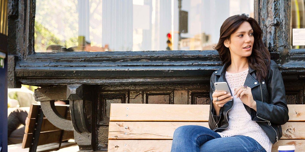 Woman sitting on a bench using a phone