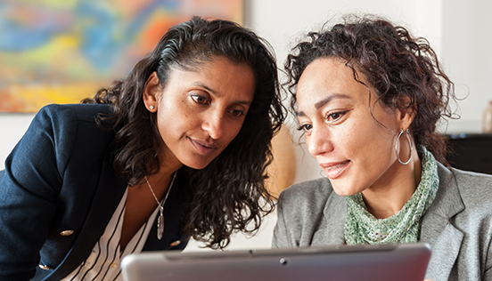 Two women looking at a computer brainstorming