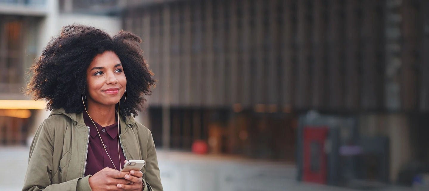 אדם עם טלפון ואוזניות הולך ברחוב.