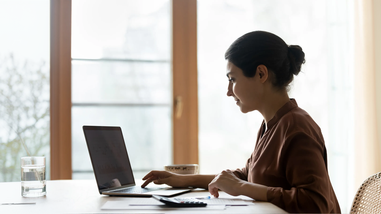 Woman with bun working on laptop