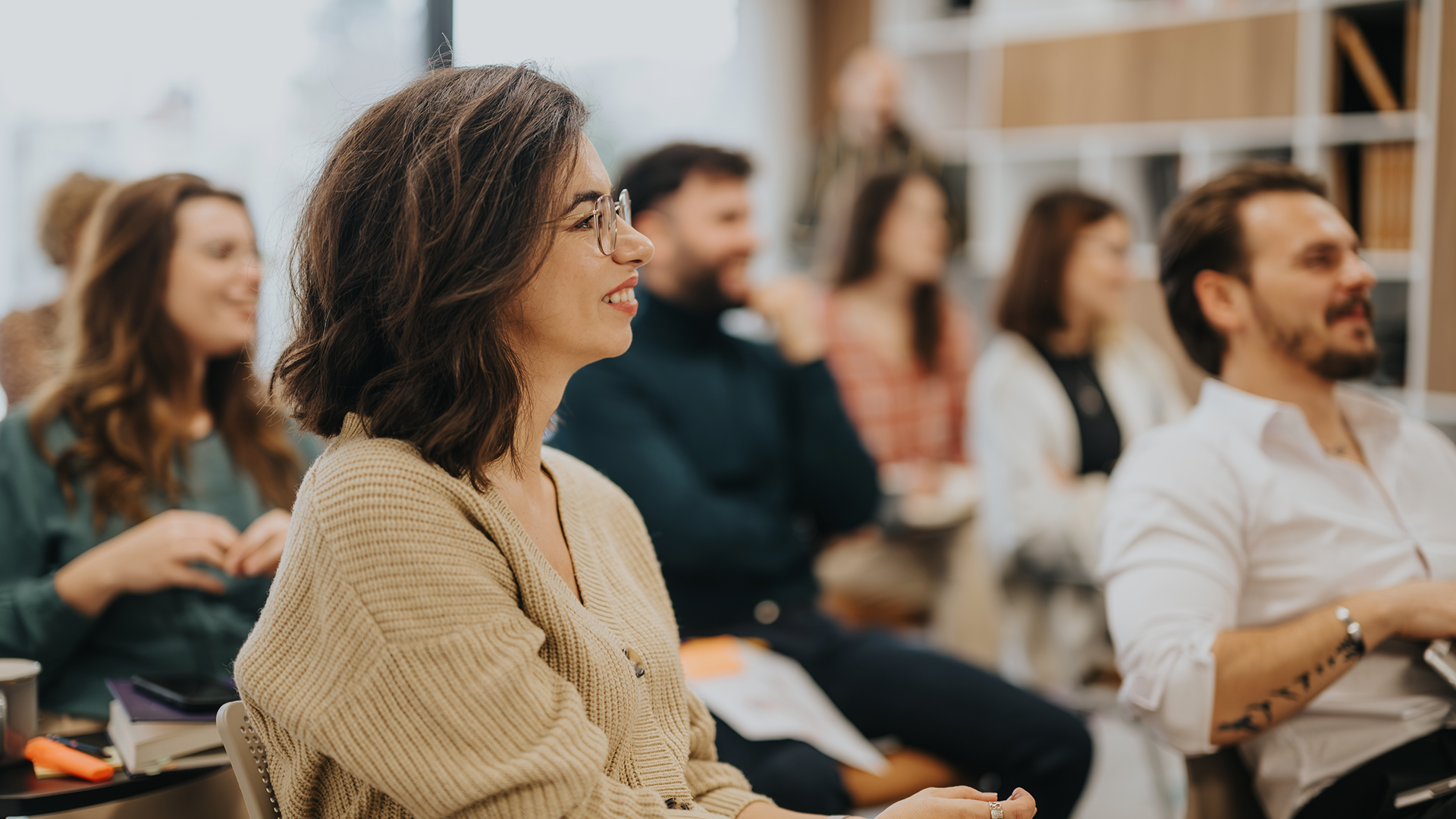 A woman sitting in a classroom with other people