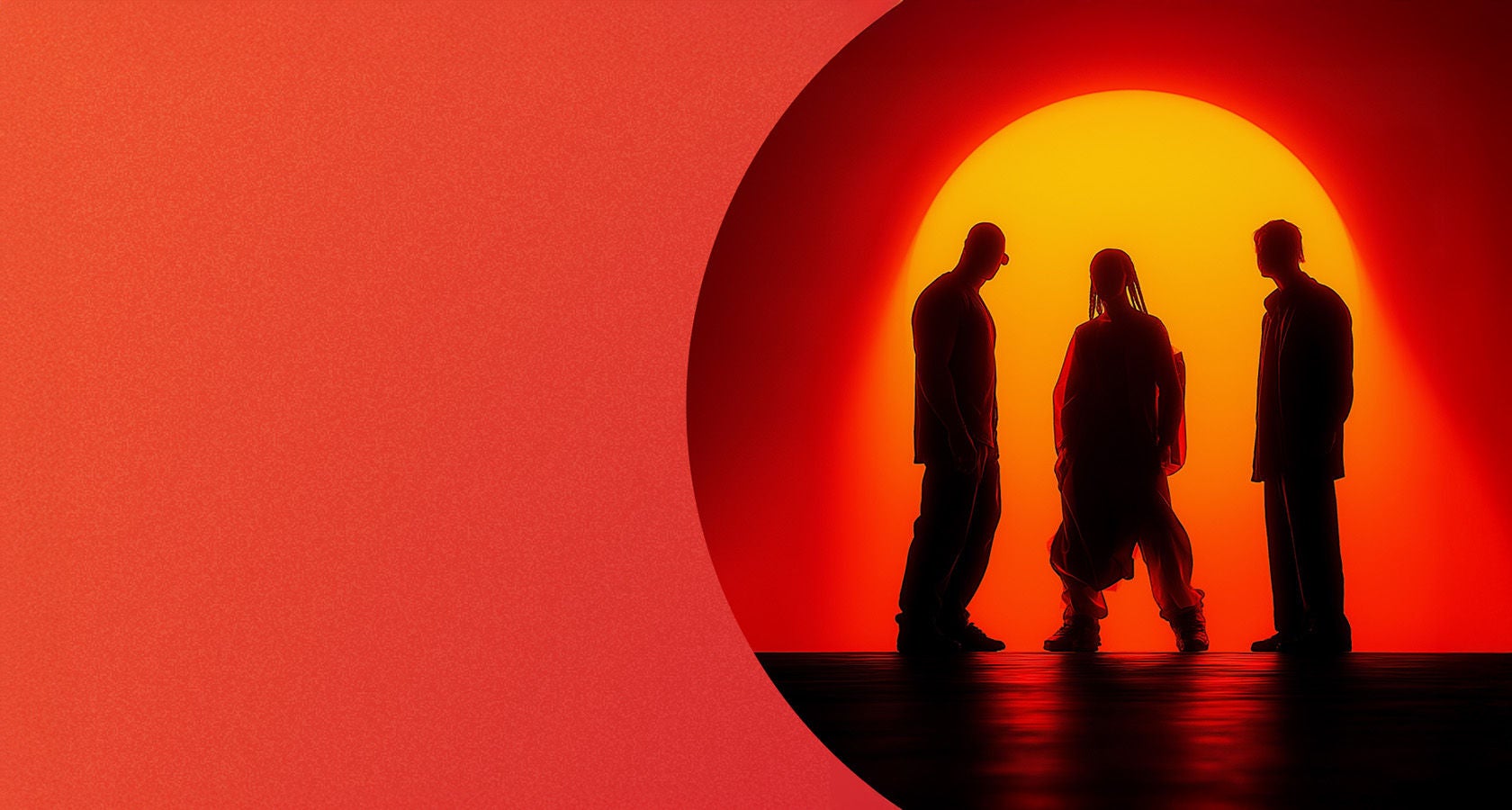 Trzy sylwetki na tle zachodzącego słońca w czerwonej poświacie.