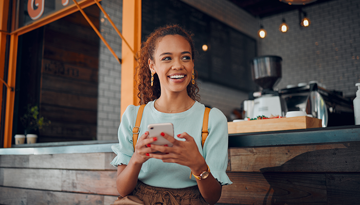 Woman in a coffee shop holding her coffee smiling