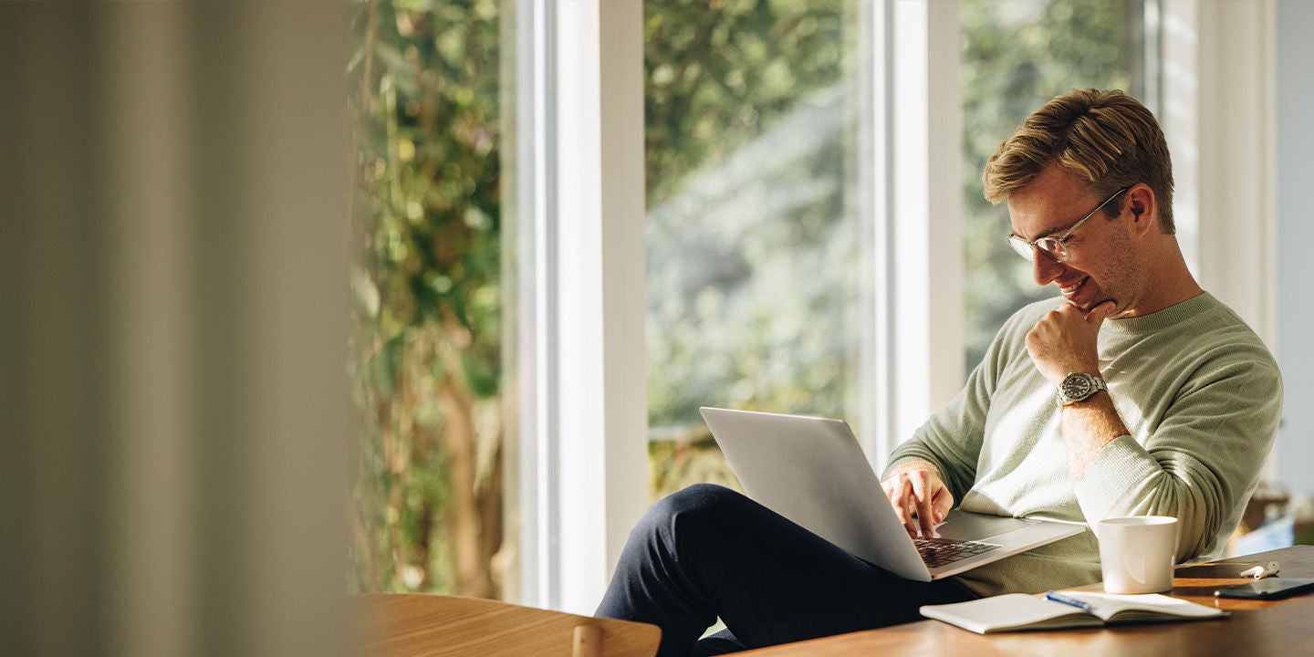 Man wearing a green sweatshirt working from home