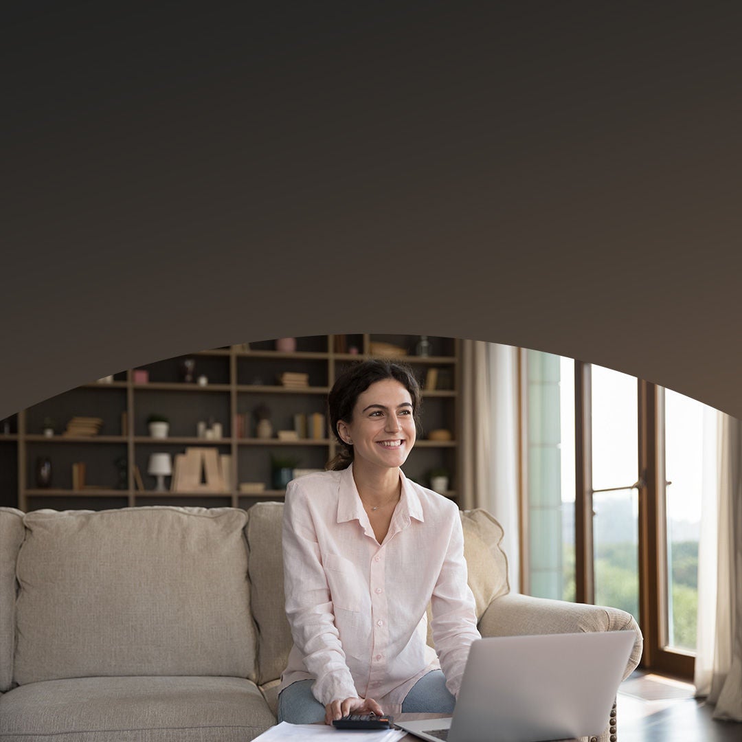 Propietario de casa joven usa contento una computadora portátil.