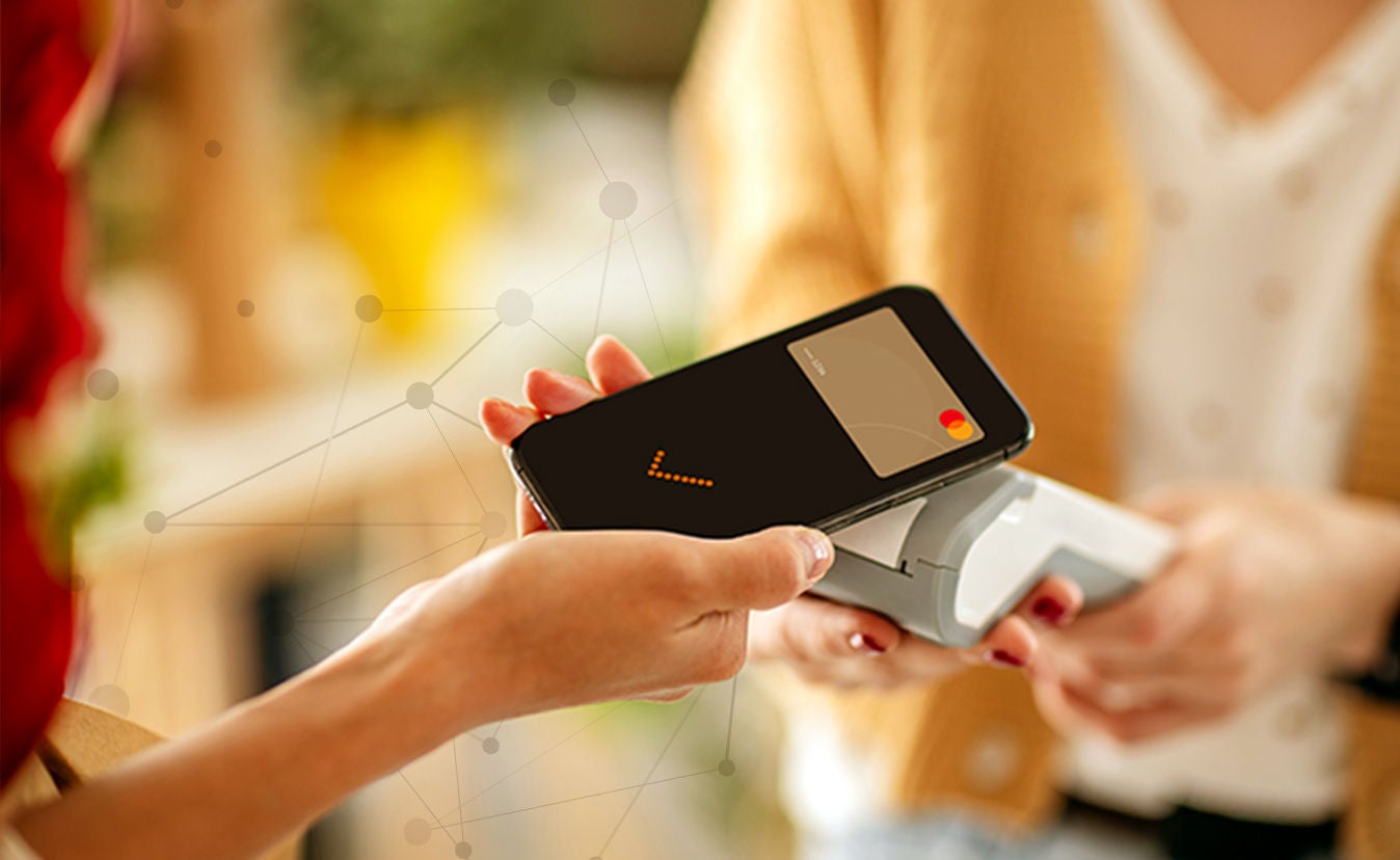 Woman using phone to pay at a shop
