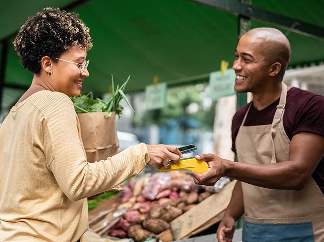 Woman paying for groceries using her phone.