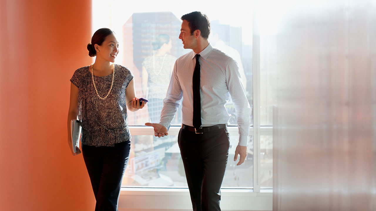 Man and woman walking in an office setting