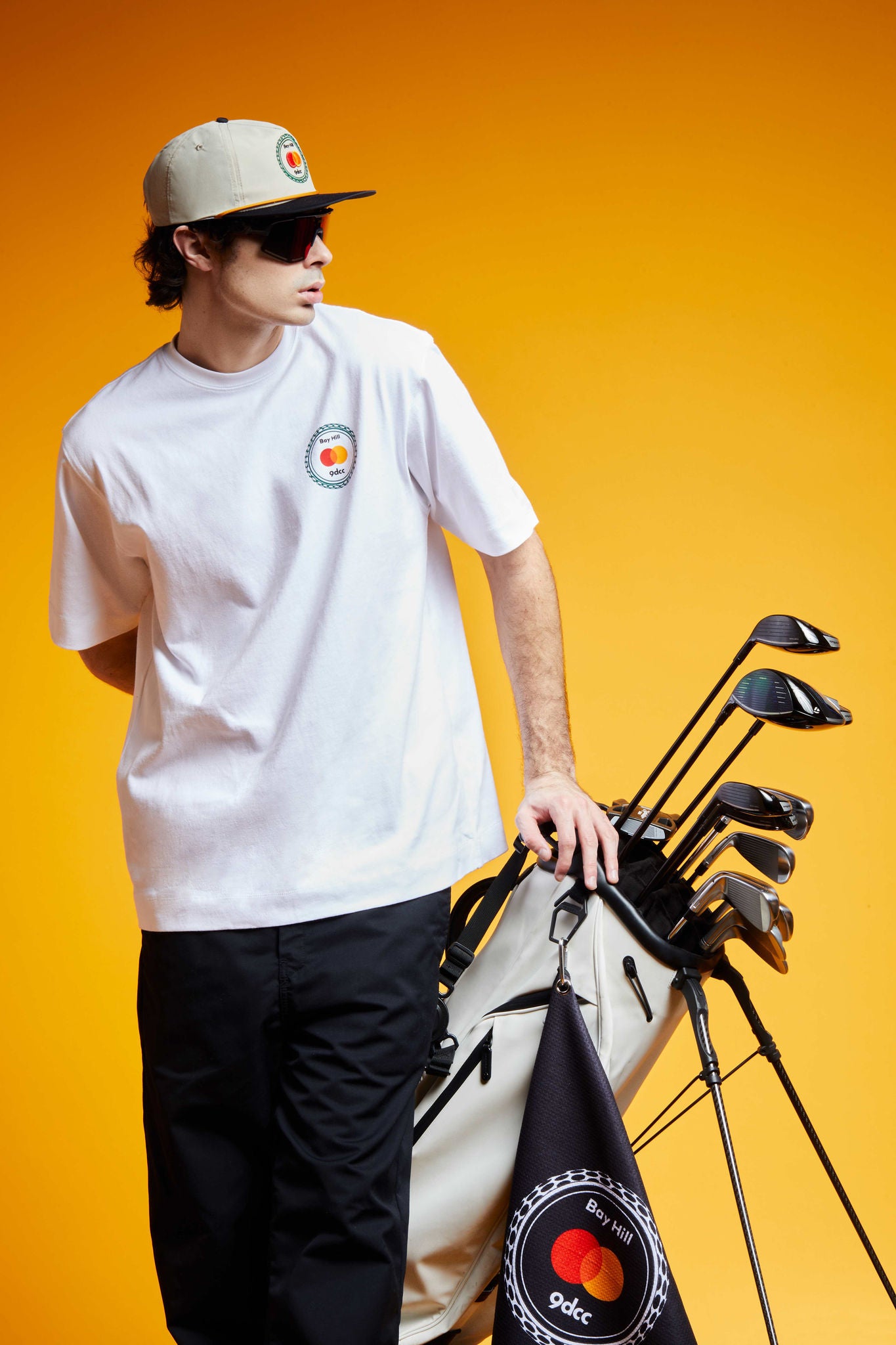 A golfer wears a t-shirt and hat designed by 9dcc