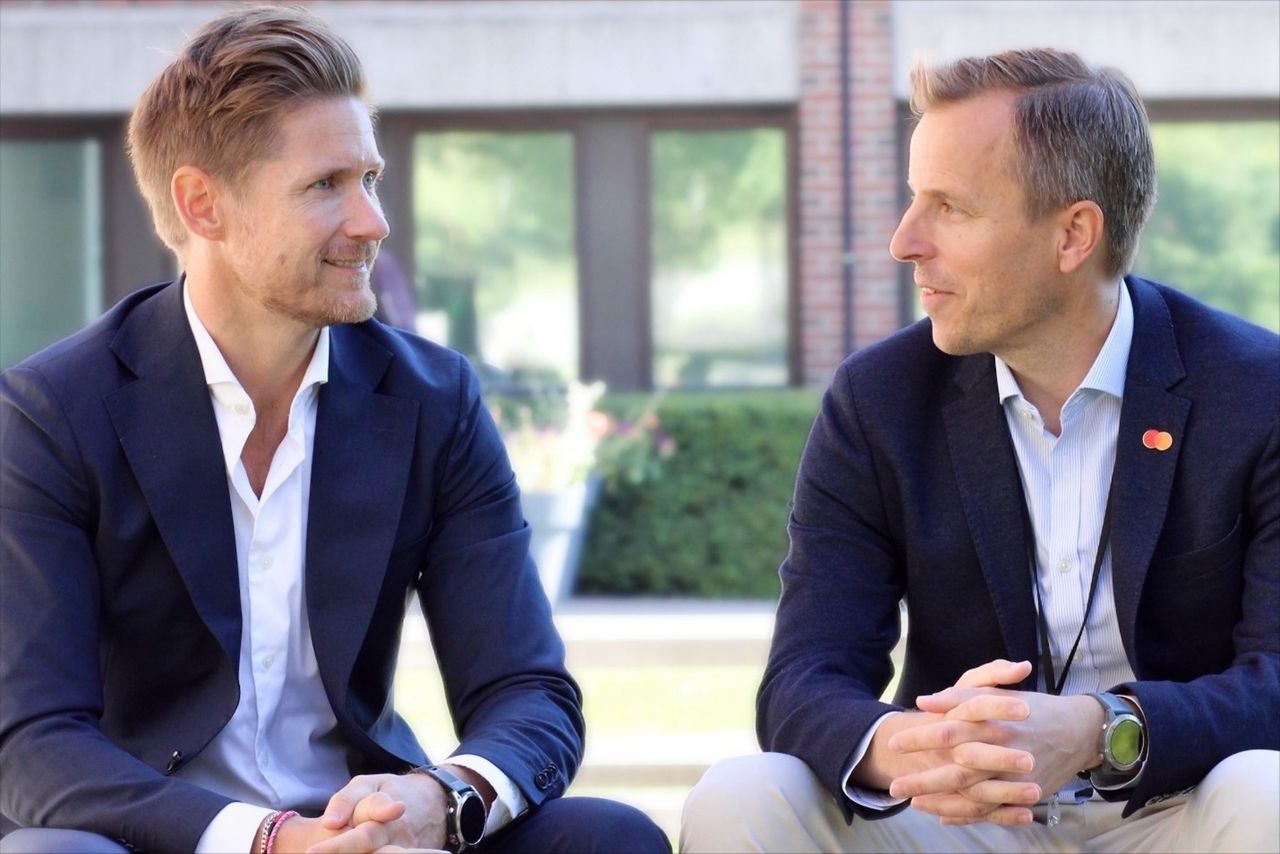 To mænd i samtale ved et professionelt arrangement.