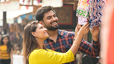 Man and woman smiling while shopping in outdoor marketplace