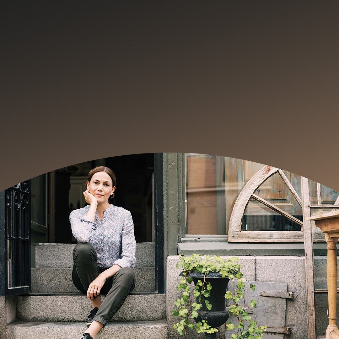 small business owner sitting on steps outside her store.