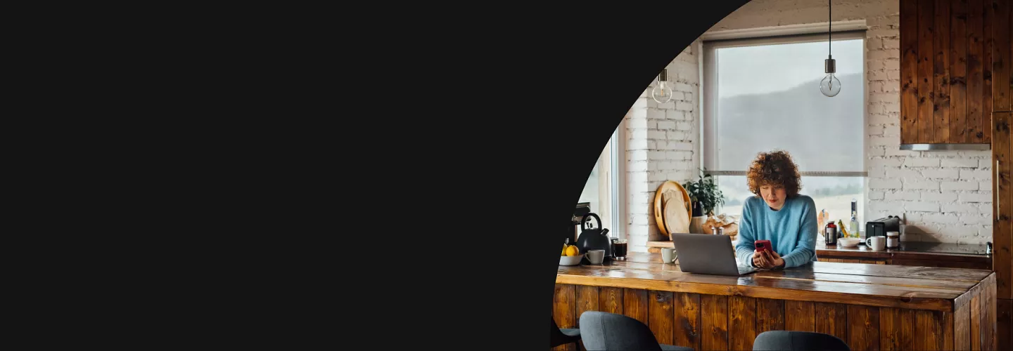 Woman looking at phone at a countertop