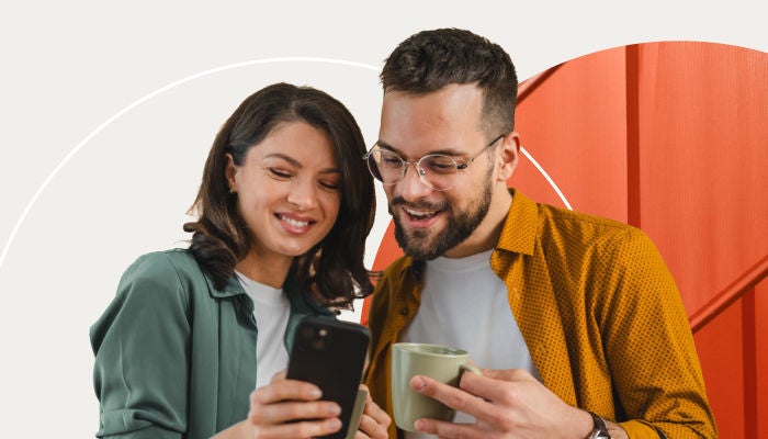 Zwei Personen schauen auf ein Telefon